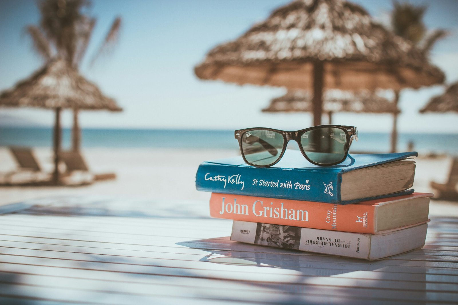 black framed Ray-Ban Wayfarer sunglasses on top of book