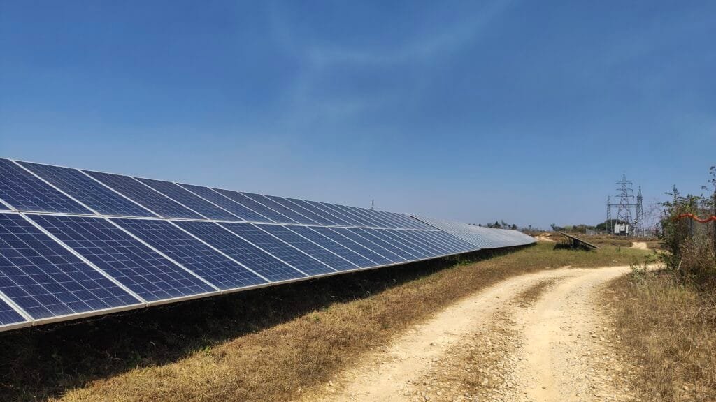 Solar panels in India with electric grid behind